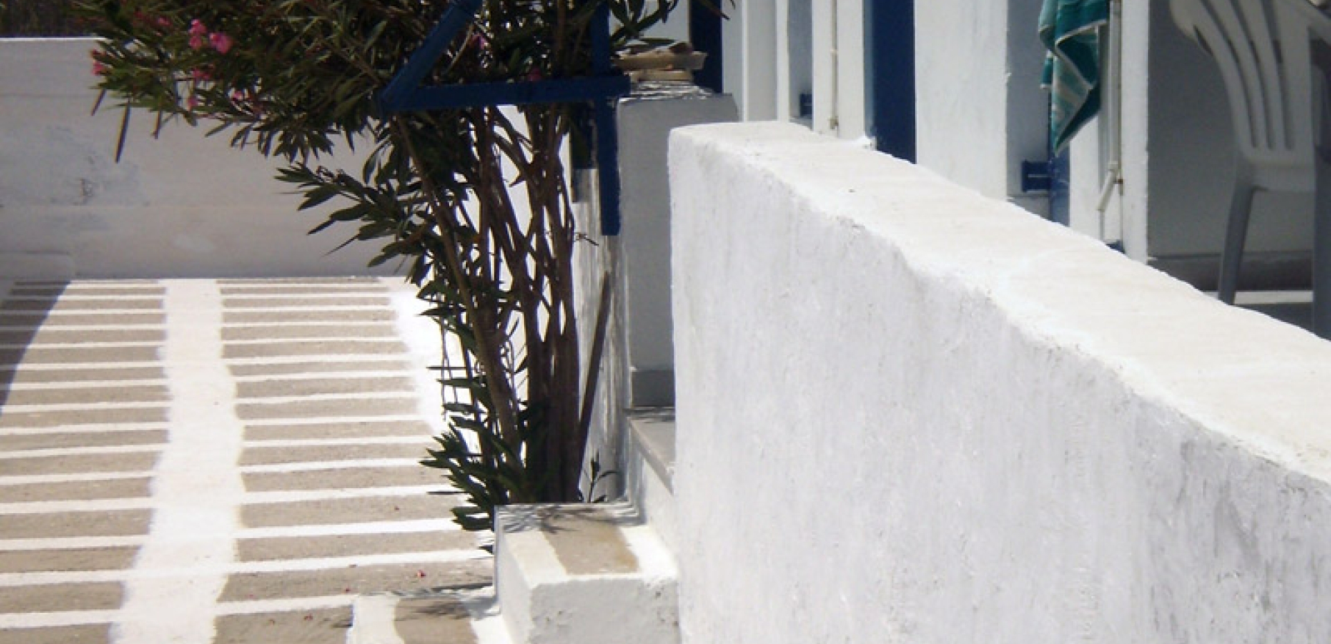 Close-up of white-washed outdoor steps and a traditional stone walkway typical of Ios island architecture.